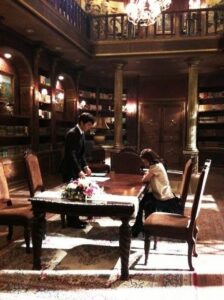 Ornate library interior with two people at table