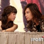 Two people leaning across table, intense eye contact