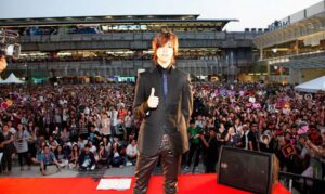 Performer posing on stage before large crowd