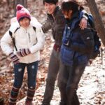 Three friends hiking in autumn forest