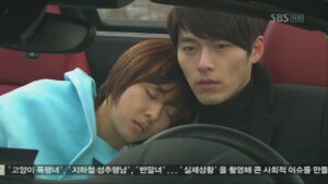 Person sleeping on companion's shoulder in car
