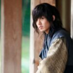 Young man with long hair in historical costume