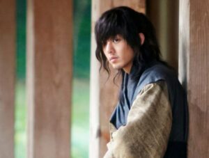 Young man with long hair in historical costume