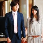 Man in suit and woman holding hands