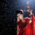 Red-robed dancer with blossom branch, snow