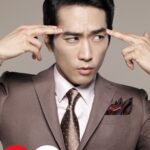 Man in suit pressing temples, concentrated expression