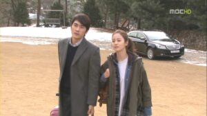 Man and woman walking near parked car