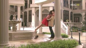 Man lifting woman in ornate courtyard