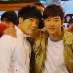 Two men smiling with arms around each other