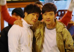 Two men smiling with arms around each other
