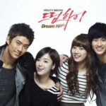 Four smiling young adults posing together