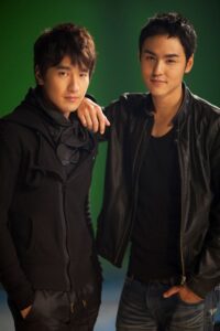 Two young men posing against green background