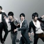 Four men in stylish suits striking dynamic poses