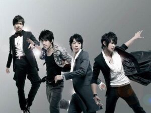 Four men in stylish suits striking dynamic poses