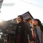 Two women walking on a sunny city street