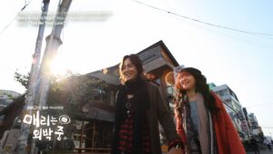 Two women walking on a sunny city street