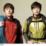 Two hikers wearing jackets with climbing rope