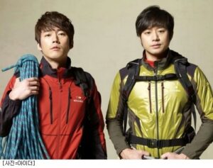 Two hikers wearing jackets with climbing rope