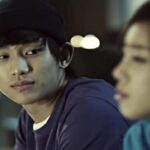 Young man in beanie looking at woman