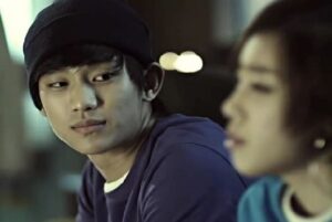 Young man in beanie looking at woman