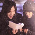 Two people reading a paper together in snow