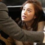 Woman looking up inside car at man