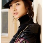 Young woman in black hat and leather jacket