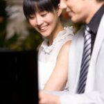 Woman smiling while man plays piano
