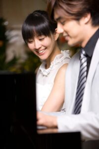 Woman smiling while man plays piano