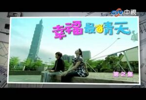 Two people sitting in park with city tower