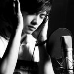 Singer recording vocals in studio with microphone