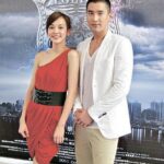Two people posing before police badge backdrop