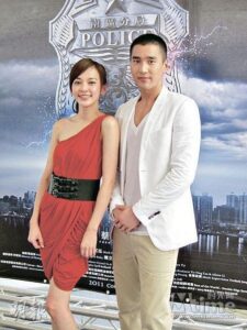 Two people posing before police badge backdrop