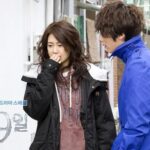 Man in blue jacket talking to distressed woman