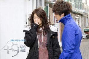 Man in blue jacket talking to distressed woman
