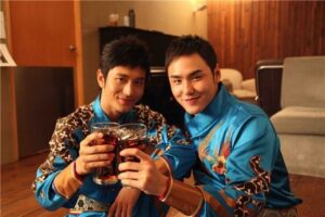 Two men in blue outfits clinking glasses