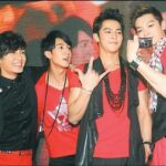 Four young men in red outfits with camcorder