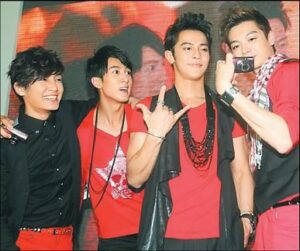 Four young men in red outfits with camcorder