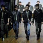 Four male models walking down fashion runway
