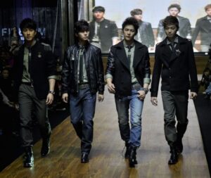 Four male models walking down fashion runway
