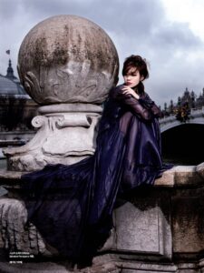 Woman in flowing dark gown on stone bridge