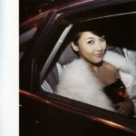 Glamorous woman in white fur coat in car