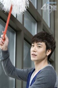 man cleaning window with white duster
