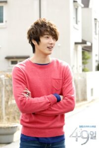 Smiling young man in pink sweater outdoors