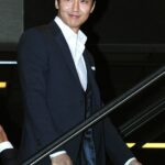 Smiling man in dark suit on escalator