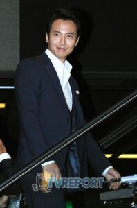 Smiling man in dark suit on escalator