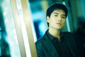 Young man leaning against glass wall