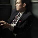 Thoughtful man in suit leaning against wall