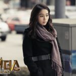 Pensive woman in coat and scarf outdoors