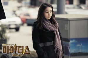 Pensive woman in coat and scarf outdoors